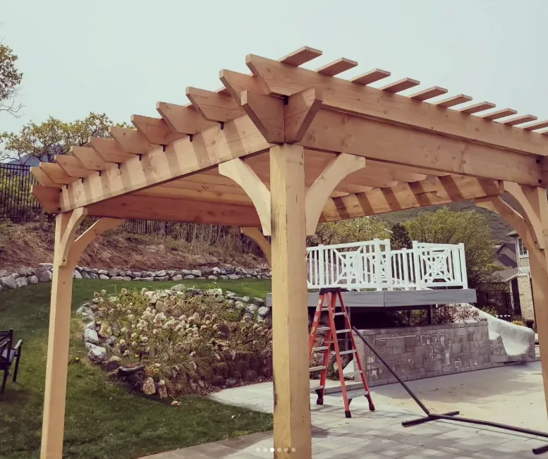Cedar pergola frame next to a raised deck by Frame Platinum LLC