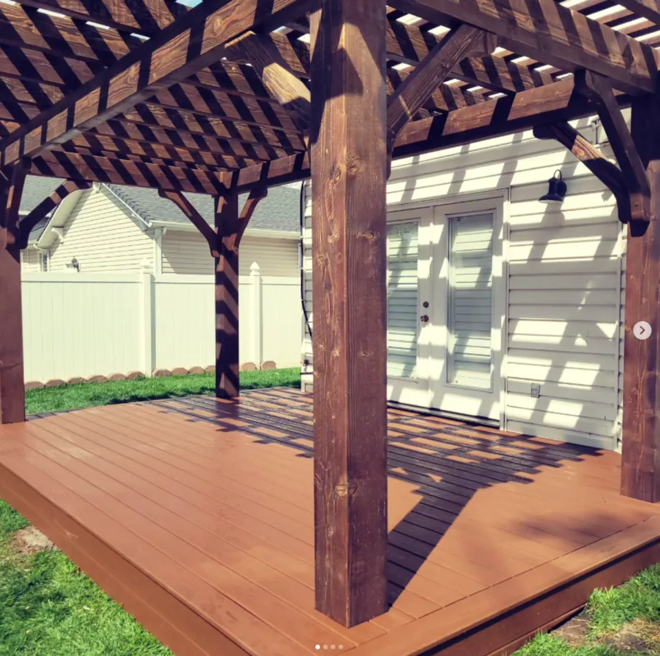 Finished dark wood pergola over a deck by Frame Platinum LLC